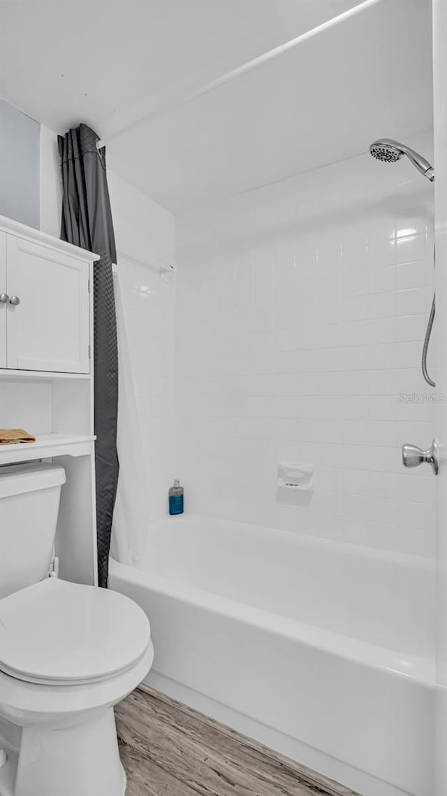 bathroom with wood-type flooring, toilet, and shower / bath combo