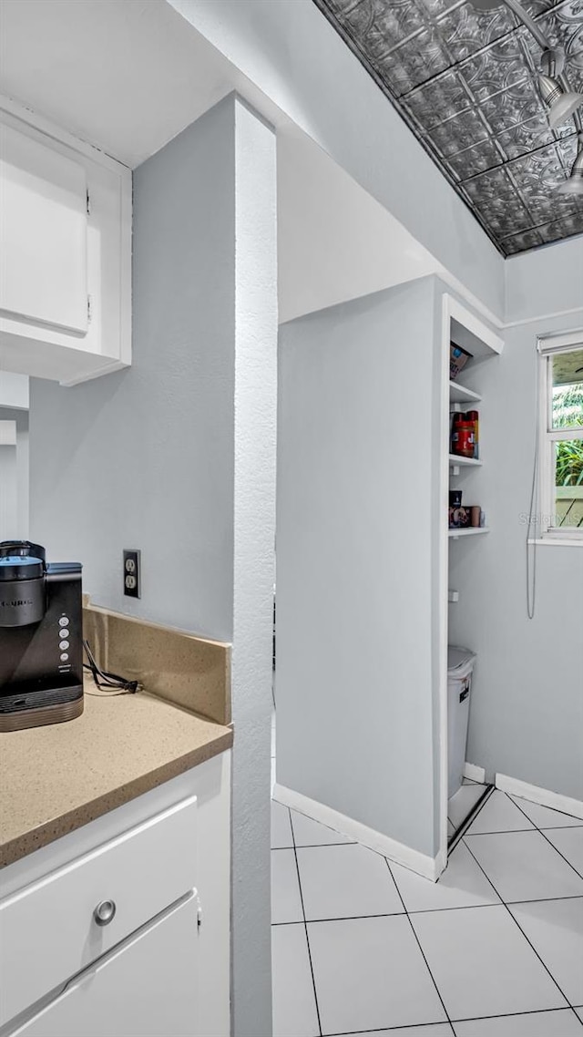 kitchen with light tile patterned floors and white cabinets