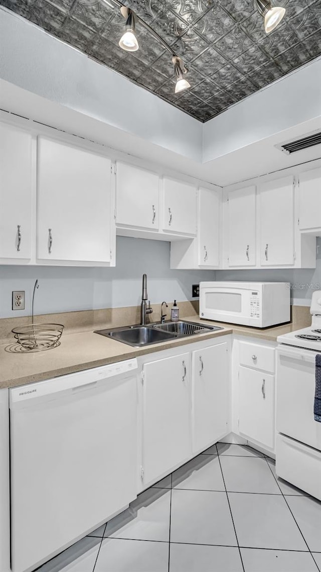 kitchen with white cabinetry, sink, white appliances, and light tile patterned floors