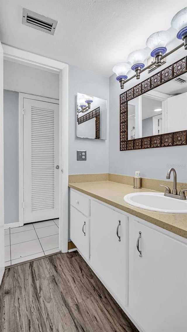 bathroom featuring vanity, hardwood / wood-style flooring, and a textured ceiling