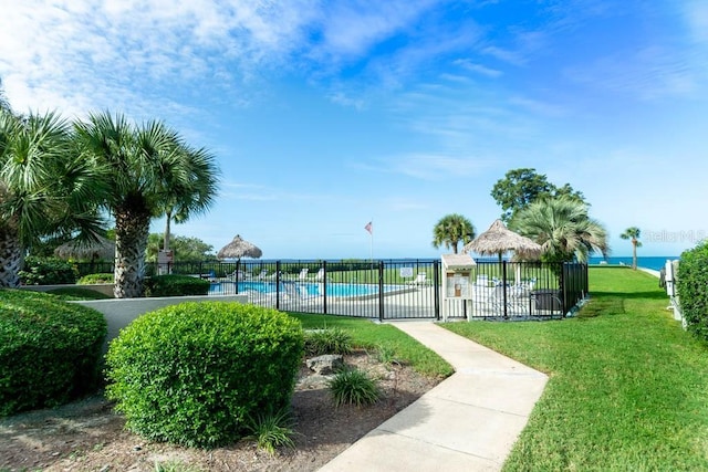 view of home's community featuring a water view, a yard, and a swimming pool