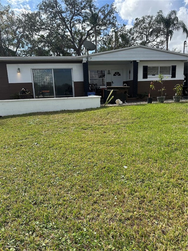 rear view of property featuring a lawn