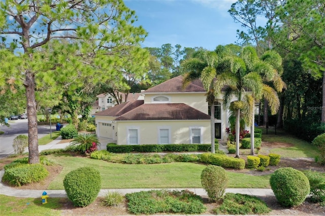 mediterranean / spanish house with a garage and a front lawn