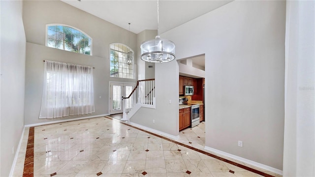 foyer entrance featuring a towering ceiling and a chandelier