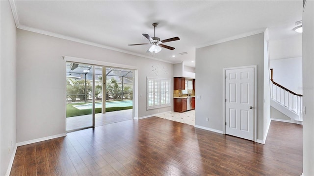 unfurnished living room featuring wood-type flooring, ornamental molding, and ceiling fan