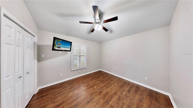 unfurnished bedroom featuring dark hardwood / wood-style flooring, a closet, and ceiling fan