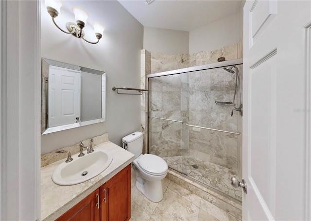 bathroom featuring vanity, a shower with shower door, and toilet