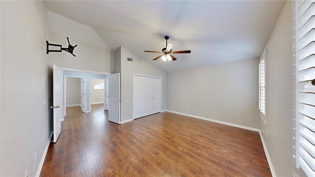 unfurnished bedroom with ceiling fan, dark hardwood / wood-style flooring, vaulted ceiling, and a closet