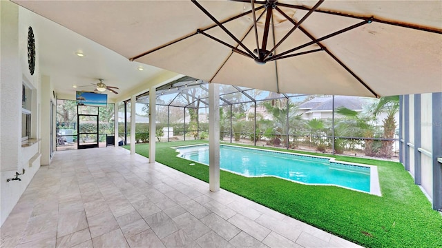 view of pool featuring ceiling fan, a yard, glass enclosure, and a patio area