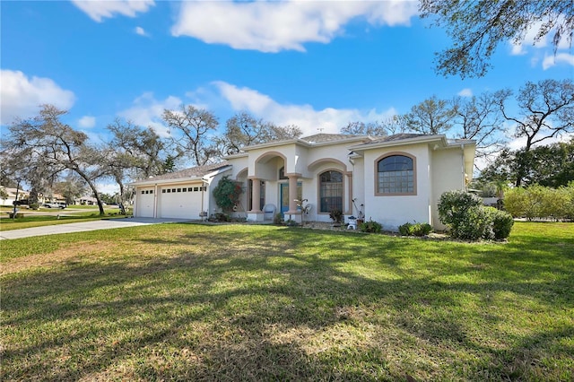 mediterranean / spanish home featuring a garage and a front yard