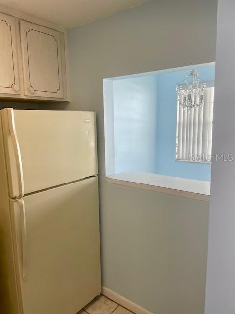 kitchen featuring light tile patterned floors, white cabinets, and white refrigerator