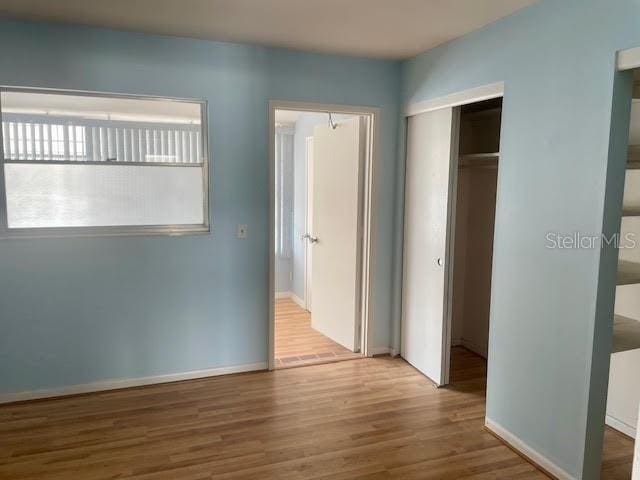 unfurnished bedroom featuring hardwood / wood-style floors and a closet