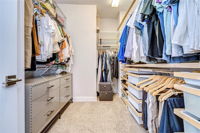 walk in closet featuring light carpet