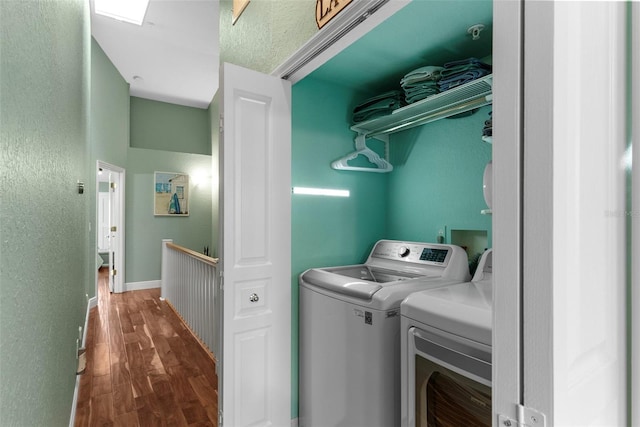 washroom with washer and dryer and dark wood-type flooring