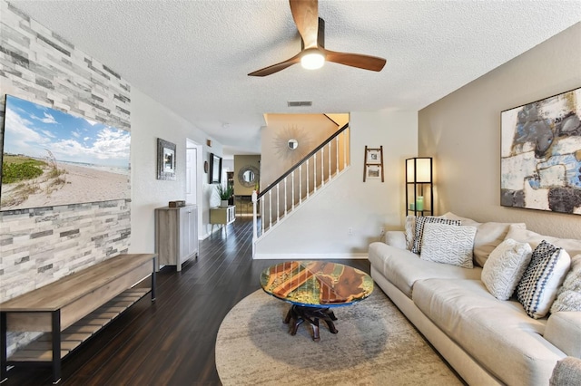 living room with ceiling fan, dark hardwood / wood-style floors, and a textured ceiling