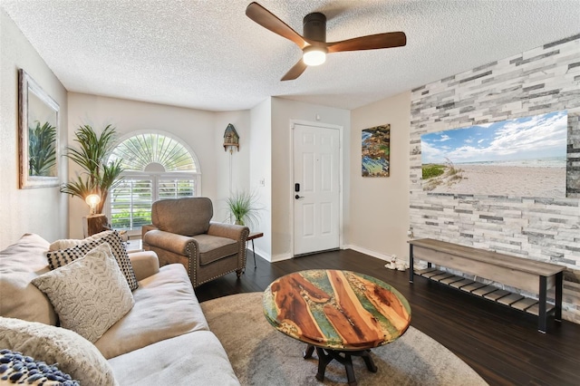 living room with ceiling fan, dark hardwood / wood-style floors, and a textured ceiling