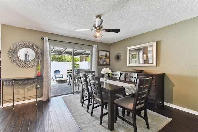 dining area featuring ceiling fan, dark wood-type flooring, and a textured ceiling