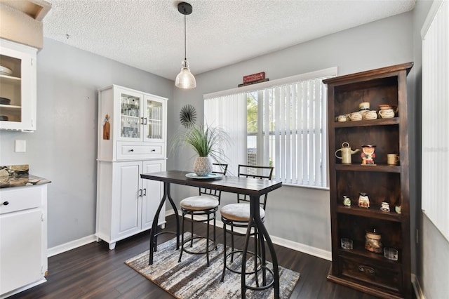 dining space featuring dark hardwood / wood-style floors and a textured ceiling