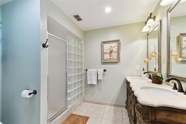 bathroom with tile patterned flooring, vanity, and an enclosed shower