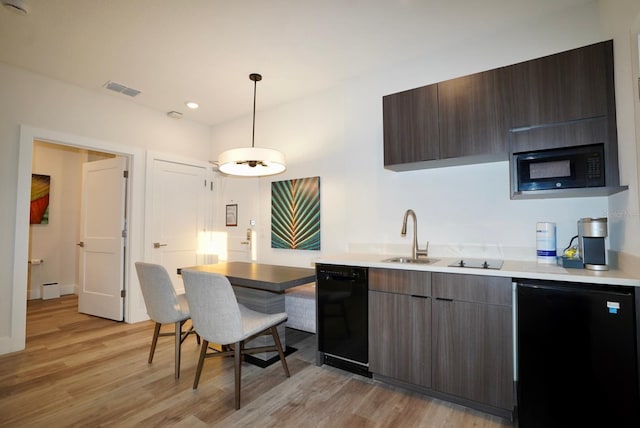 15695 Grove Resort Ave Unit 4303, Winter Garden, FL 34787 - kitchen with black appliances, a sink, light wood-style floors, light countertops, and modern cabinets
