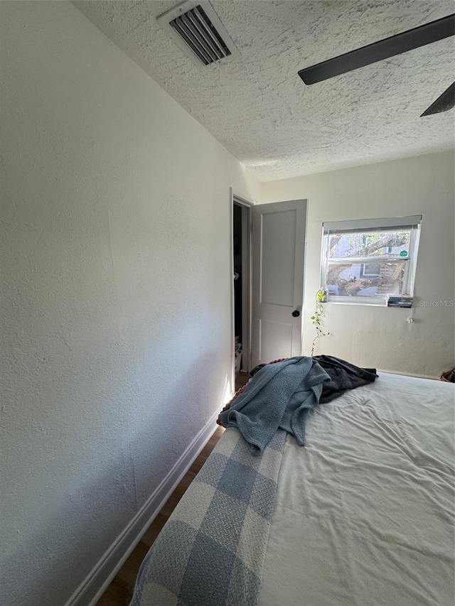 bedroom featuring wood-type flooring and a textured ceiling