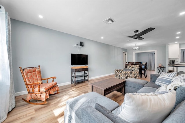 living room featuring light hardwood / wood-style flooring and ceiling fan