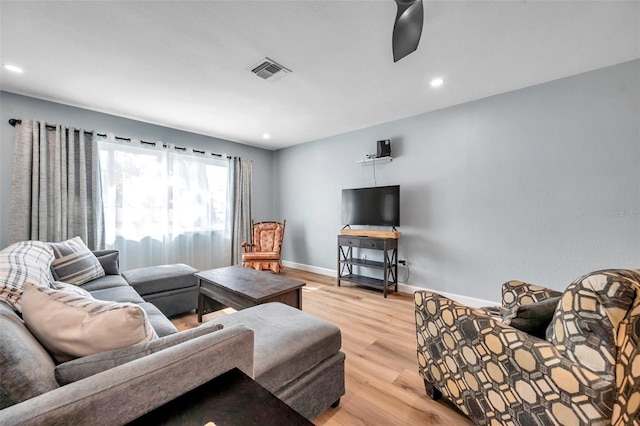 living room with light hardwood / wood-style flooring and ceiling fan