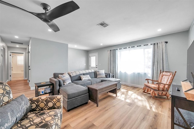 living room with light hardwood / wood-style flooring and ceiling fan