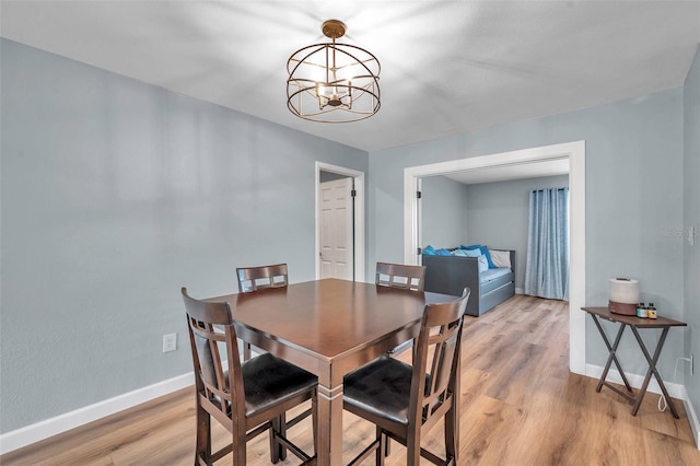 dining area featuring hardwood / wood-style floors and an inviting chandelier