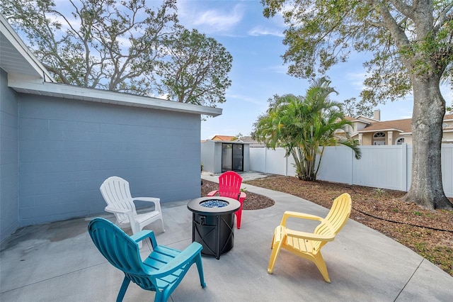 view of patio / terrace featuring a shed and a fire pit