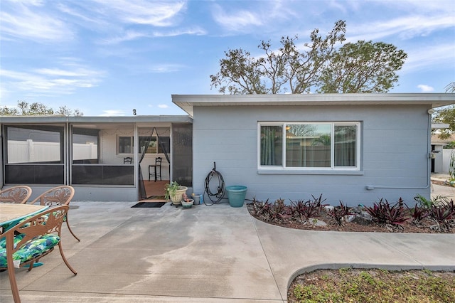 rear view of house featuring a patio and a sunroom