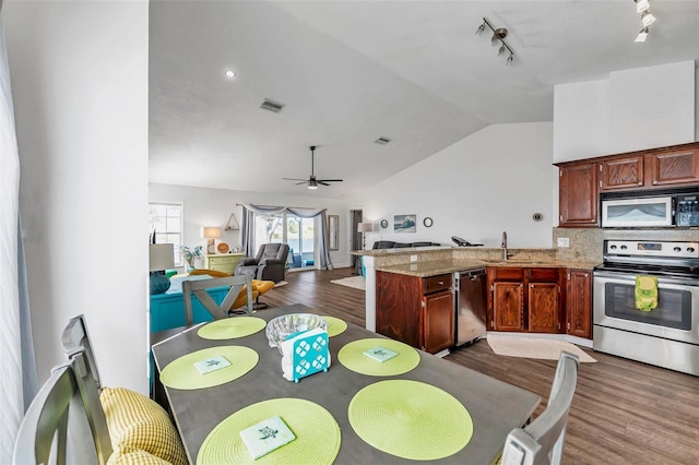 dining area featuring vaulted ceiling, dark hardwood / wood-style floors, sink, and ceiling fan