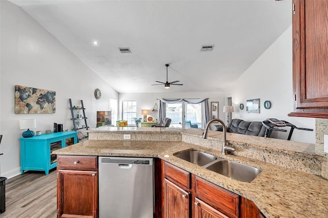 kitchen featuring sink, ceiling fan, light hardwood / wood-style floors, vaulted ceiling, and stainless steel dishwasher