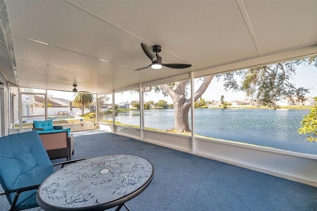 sunroom / solarium featuring ceiling fan and a water view