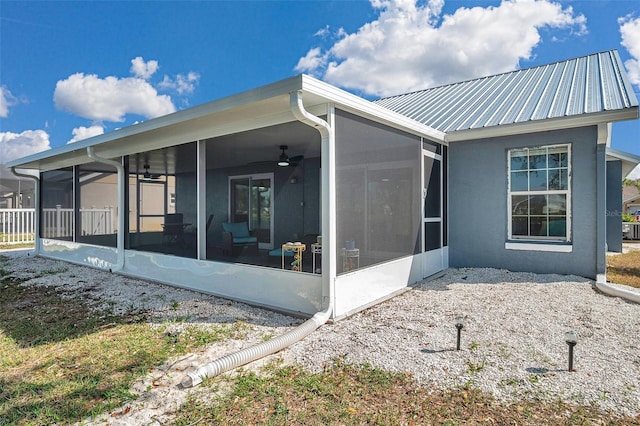 view of side of home with a sunroom and ceiling fan