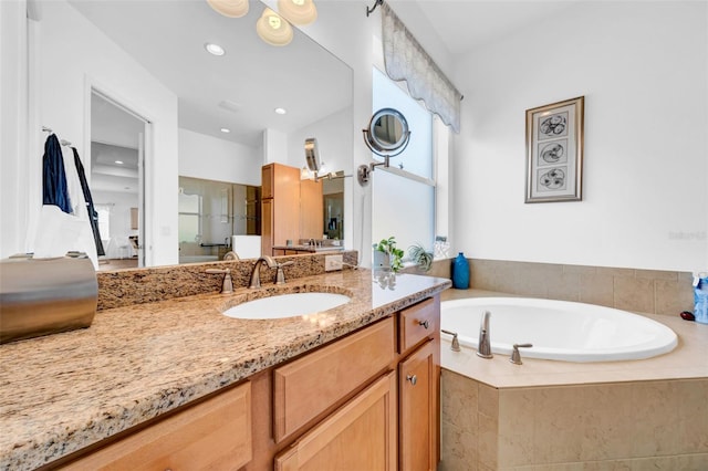 bathroom featuring vanity and tiled bath