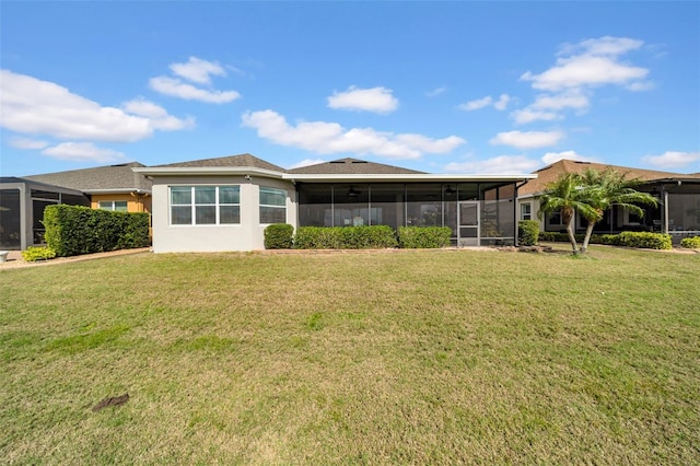 rear view of property with a sunroom and a lawn