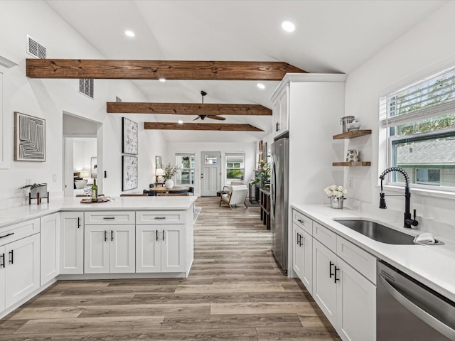 kitchen with lofted ceiling with beams, white cabinetry, sink, light hardwood / wood-style floors, and stainless steel appliances