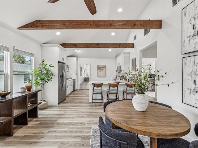 dining space with light hardwood / wood-style flooring, lofted ceiling with beams, and ceiling fan