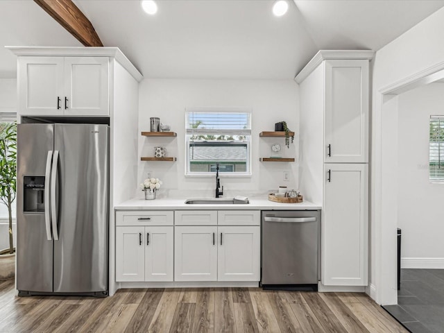 kitchen with white cabinetry, appliances with stainless steel finishes, light hardwood / wood-style floors, and sink