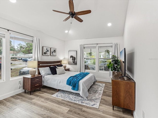 bedroom with multiple windows, hardwood / wood-style flooring, lofted ceiling, and ceiling fan