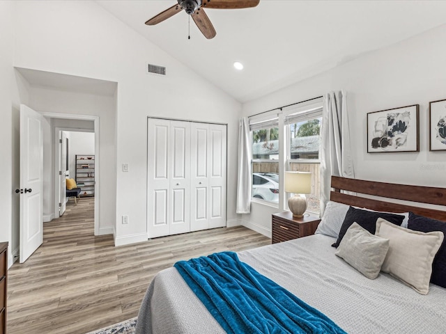 bedroom featuring ceiling fan, high vaulted ceiling, light hardwood / wood-style floors, and a closet