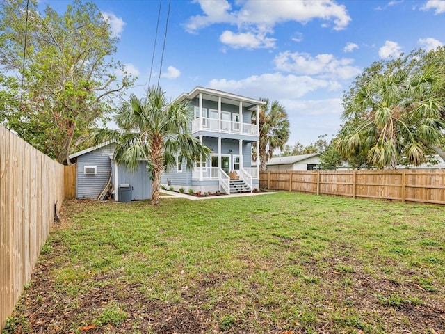 back of property featuring a balcony and a lawn