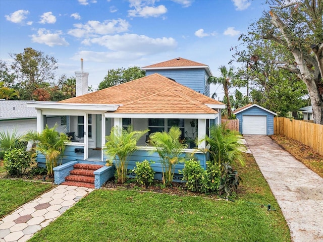 bungalow-style home featuring an outbuilding, a garage, and a front yard