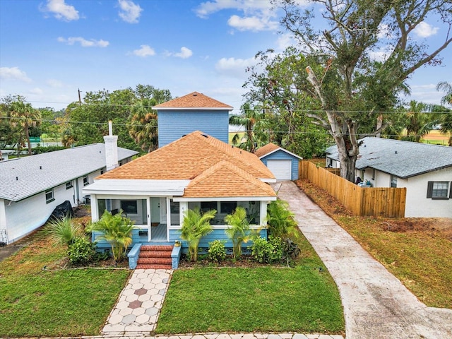 view of front of house with an outbuilding, a garage, and a front yard