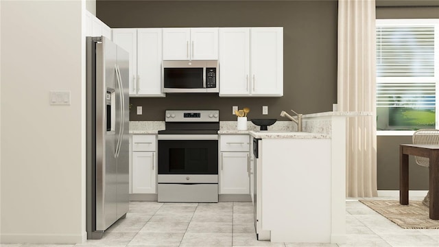 kitchen with white cabinetry, appliances with stainless steel finishes, light tile patterned flooring, and light stone counters