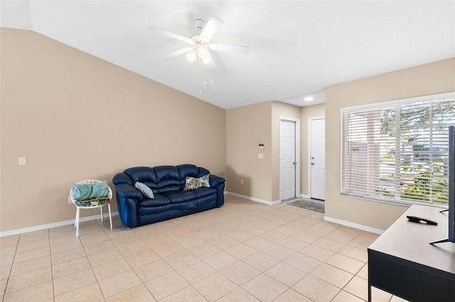 sitting room with ceiling fan, light tile patterned floors, and vaulted ceiling