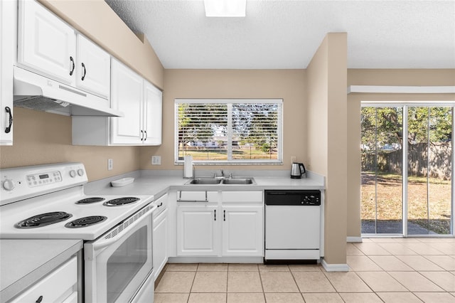 kitchen featuring white appliances, light tile patterned floors, sink, and white cabinets