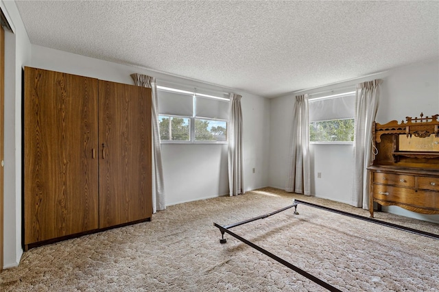 bedroom featuring light colored carpet and a textured ceiling