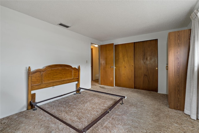 carpeted bedroom featuring a textured ceiling and a closet